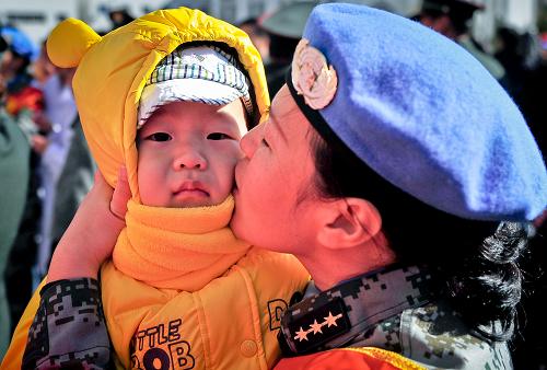 11月13日,一位維和部隊(duì)醫(yī)療分隊(duì)的女隊(duì)員與自己的孩子吻別。新華社記者 張超群 攝