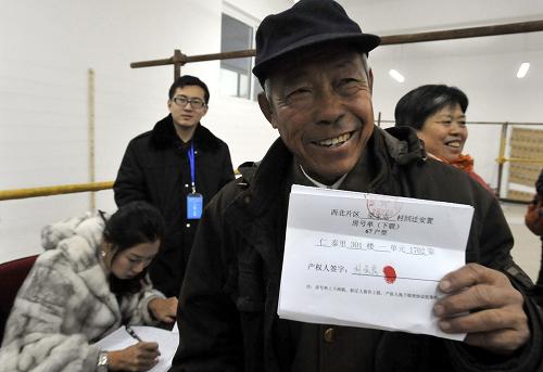 11月16日,從小居住在棚戶區(qū)平房的梁家屯村村民劉金良老人一大清早就趕來排隊選房號,成為第一個選到稱心如意住房的回遷群眾。新華社發(fā)(鄭勇 攝)