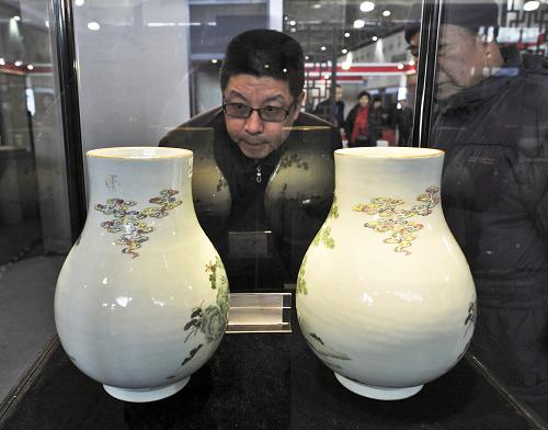 12月8日,觀眾在2012北京·中國文物國際博覽會上觀看清道光年間的粉彩人物鹿鶴尊。新華社發(fā)(王京生 攝)