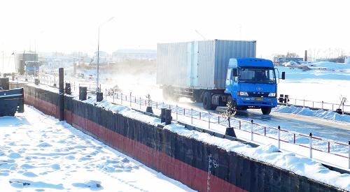 12月11日,黑龍江省黑河市集裝箱貨車通過中國黑河至俄羅斯布拉戈維申斯克浮箱固冰通道駛往俄布市口岸。新華社發(fā)(邱齊龍 攝)