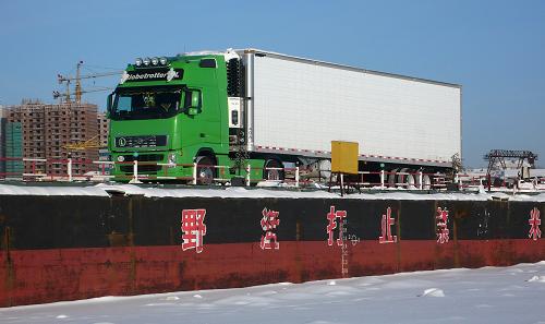 12月11日,俄羅斯集裝箱貨車通過中國黑河至俄羅斯布拉戈維申斯克浮箱固冰通道駛往黑河口岸。新華社發(fā)(邱齊龍 攝)