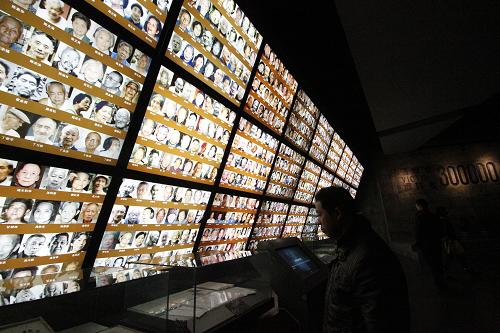 12月11日,人們在侵華日軍南京大屠殺遇難同胞紀念館內(nèi)的幸存者照片前參觀。新華社發(fā)(董金林 攝)