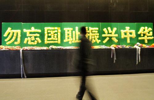 12月11日,一名男子從侵華日軍南京大屠殺遇難同胞紀念館“勿忘國恥 振興中華”的告示板前走過。新華社發(fā)(董金林 攝)
