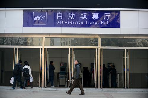 12月12日,旅客從蘭州火車站自助取票廳旁經(jīng)過。新華社記者 張錳 攝