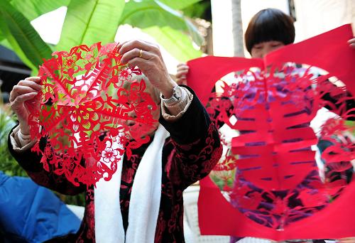 12月28日,民間剪紙藝人向市民展示現(xiàn)場制作的剪紙作品。新華社記者林善傳攝