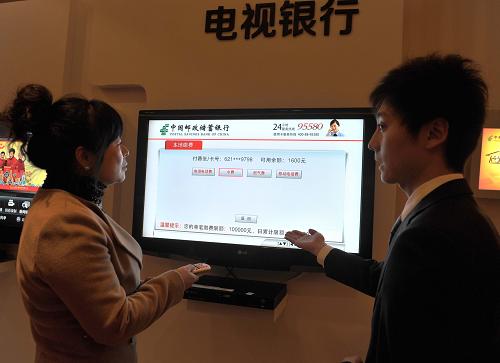12月28日,一位女士在工作人員的幫助下體驗“電視銀行”。新華社記者 李文 攝