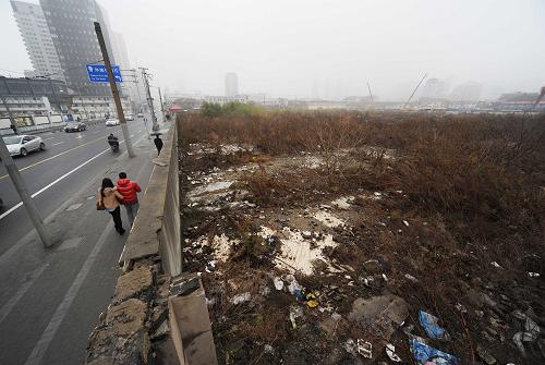 12月28日,行人從上海海門(mén)路55號(hào)地塊旁邊經(jīng)過(guò)。日前,上海市海門(mén)路55號(hào)地塊被上海國(guó)際港務(wù)集團(tuán)股份有限公司聯(lián)合威旺置業(yè)有限公司摘得,總價(jià)56.8億元,成為2012年國(guó)內(nèi)總價(jià)“地王”。 據(jù)悉,海門(mén)路55號(hào)地塊位于上海市中心核心地段,成交樓面價(jià)格23330元/平方米,溢價(jià)率21.11%。新華社發(fā)(賴鑫琳 攝)