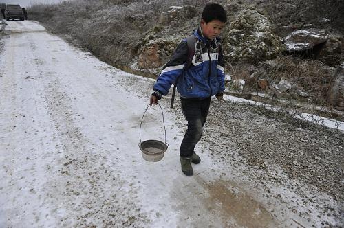 1月6日,在甕安縣平定營(yíng)鎮(zhèn)細(xì)沙村,一名學(xué)生自帶炭火準(zhǔn)備去上課。新華社記者 歐東衢 攝