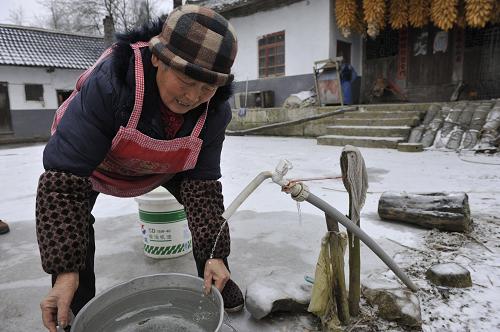 1月6日,甕安縣平定營(yíng)鎮(zhèn)細(xì)沙村70歲的村民曾慶林在冰凍的院子內(nèi)接水。目前,當(dāng)?shù)厥転?zāi)群眾水電供應(yīng)基本正常。新華社記者 歐東衢 攝