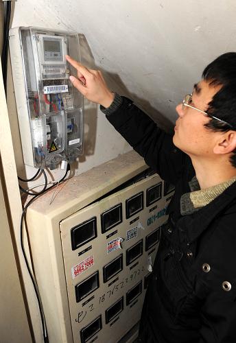 1月13日,徐鵬飛在樓梯間查看自家“發(fā)電廠”的發(fā)電量。新華社記者 李紫恒 攝