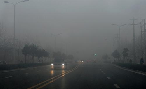 1月14日,石家莊街頭的車輛開啟照明燈行駛。新華社發(fā)(王曉 攝)