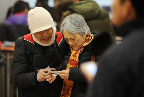 1月14日,在成都火車站售票大廳,旅客在查看剛買到的車票。新華社發(fā)(李華梁 攝)