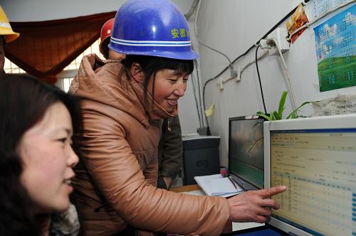 1月15日,參與建設(shè)合肥市雙窯洞棚戶區(qū)改造工程的重慶籍建筑工人魏玉桂(右)在社區(qū)工作人員的幫助下預(yù)訂返鄉(xiāng)的車票。新華社記者 杜宇 攝