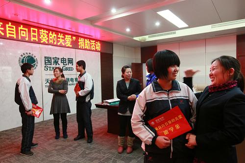 1月15日,國家電網(wǎng)天津?qū)幒庸締T工(前右)和貧困學(xué)生結(jié)成一對一幫扶對子。新華社發(fā)(任麗華 攝)