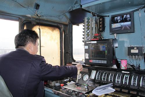 乘務(wù)員正通過“千里眼”、機車信號顯示器,查看前方線路情況和地面信號顯示(1月14日攝)。新華社發(fā)(林非攝)