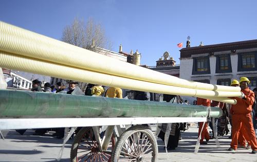 1月16日,施工人員在大昭寺廣場前搬運(yùn)管道。新華社記者 普布扎西 攝