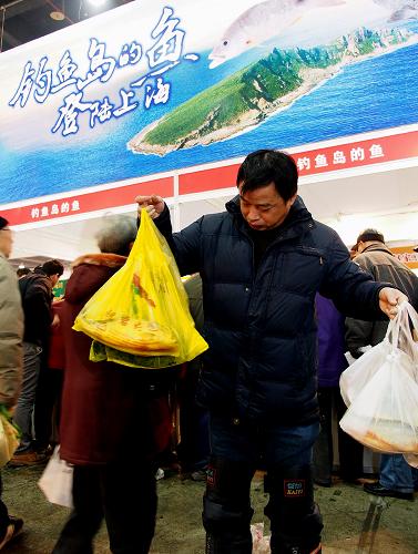 1月26日,一名顧客拿著從釣魚島鮮魚攤位上買到的深海魚。新華社記者 陳飛 攝