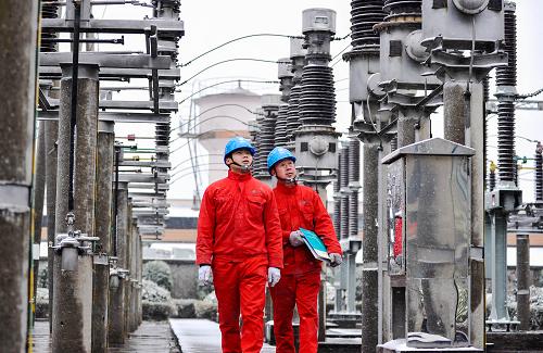 2月8日,湖州市長興縣供電局黨員服務(wù)隊隊員冒雪巡視變電設(shè)備保障用電。新華社記者 徐昱 攝