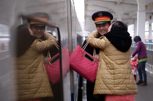 2月14日,在南昌火車站站臺(tái)上,開(kāi)往長(zhǎng)沙的D117列車列車長(zhǎng)萬(wàn)霖的新婚妻子鄭艷抱住丈夫親吻。1月剛剛完婚的萬(wàn)霖來(lái)不及休完婚假就投入春運(yùn),妻子鄭艷趁列車在南昌停留的幾十分鐘時(shí)間送丈夫禮物。當(dāng)日是西方的情人節(jié),恰逢正月初五,大批旅客踏上返程列車。在南昌火車站,忙碌的客流人潮中點(diǎn)綴著愛(ài)情的色彩,顯得格外溫馨與浪漫。新華社記者周密攝