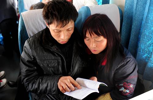 2月26日,一對從四川來沈陽務工的夫婦在閱讀工作人員發(fā)放的《農民工招聘信息手冊》。新華社發(fā)(姜冰 攝)