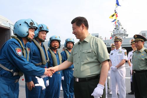 這是4月9日,習(xí)近平在井岡山艦上與艦載直升機(jī)飛行員親切握手。新華社記者 李剛 攝