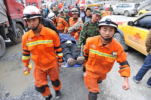 4月22日,消防官兵抬著寶興縣臨時(shí)醫(yī)院的一名準(zhǔn)備轉(zhuǎn)運(yùn)的傷員在寶興縣的街道上快速前行。新華社記者 劉潺 攝
