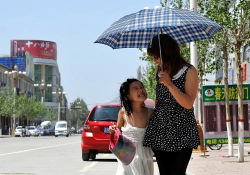 5月11日,一對(duì)母女撐傘走在保定市街頭。新華社發(fā)(朱旭東 攝)