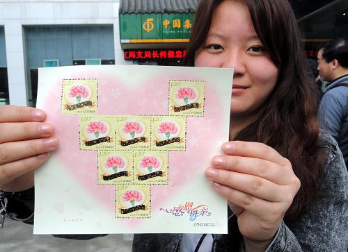 5月11日,一名集郵愛好者在江蘇蘇州郵政局展示剛購買的《感恩母親》特種郵票心型小版。 當(dāng)日,中國郵政發(fā)行《感恩母親》特種郵票一套1枚,面值1.20元,該套郵票是中國郵政發(fā)行的首套“刮出祝福”郵票。 該套郵票主設(shè)計元素為“母親花”康乃馨花及心形圖案,刮開每枚郵票的金色絲帶覆蓋層,均可顯出一條感恩母親的祝福語。祝福語共四條,分別為“媽媽,我愛您”、“祝媽媽永遠(yuǎn)幸福”、“世上只有媽媽好”、“謝謝媽媽養(yǎng)育之恩”。 新華社發(fā)(王建康 攝)