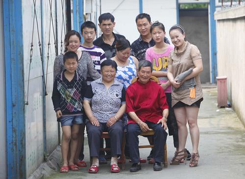 2011年5月7日是卞剛芬父親的生日,他們全家團聚在父母暫住的板房慶賀壽辰。因當地政府將地震遺址規(guī)劃發(fā)展旅游業(yè),卞剛芬父母這樣的老齡失地農民每月可領取700元左右的生活費。 采訪節(jié)點:2008年、2011年、2013年 家庭成員:卞剛芬(36歲)一家三口 家庭現狀:幾經輾轉,一家人仍然住在臨時過渡房里,住進新房成為了他們全家的心愿。 2013年4月30日,在位于四川省什邡市師古鎮(zhèn)的一間教室改成的住房里,記者見到了卞剛芬一家。 原本一間空曠的教室,被豎立的水泥墻隔成了兩間,擁擠的空間里,電腦、電視、柜子和床,無論怎么擺看起來都不那么協調,但這已經比卞剛芬之前住的板房好了一些。 5年前的卞剛芬,曾經一度成為“明星”。她當時是四川鎣峰實業(yè)有限公司茶樓里的臨時工,因在廢墟里埋了124小時被消防隊員成功營救,被眾多媒體爭相報道,成為村里家喻戶曉的人物。 之后,曾經救援過她的消防官兵來看望她時,卞剛芬因為說要“請大家喝茅臺”而上了《人民日報》。后來,茅臺集團的領導提著一箱茅臺找到她,她又帶著茅臺進行了“感恩之旅”。卞剛芬還在20