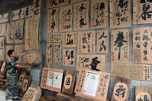 5月25日,在四川省雅安市蘆山縣先鋒居民小區(qū),彭勇在家中整理書(shū)法作品。 “4·20”蘆山地震發(fā)生后,四川省雅安市蘆山縣居民彭勇將自家院落讓給記者使用,并義務(wù)為記者們提供食宿。4月21日至25日期間,前往彭勇家發(fā)稿的記者數(shù)量達(dá)到頂峰,最多時(shí)一天接待130多名記者。如今這個(gè)小院被書(shū)法家高凱用書(shū)法作品裝扮一新,書(shū)法作品內(nèi)容大多是摘抄記者留下的祝福、感謝話(huà)語(yǔ)。這個(gè)曾經(jīng)的“記者之家”成為了災(zāi)區(qū)的“精神家園”。新華社發(fā)(李向雨 攝)