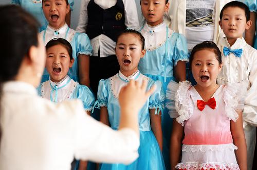 5月31日,“小水滴”合唱團(tuán)在排練節(jié)目。 哈爾濱市香坊區(qū)成高子鎮(zhèn)香和小學(xué)位于哈爾濱市城鄉(xiāng)結(jié)合部,學(xué)校有110多名留守兒童。2010年,該校成立了“小水滴”合唱團(tuán)。據(jù)該校大隊(duì)輔導(dǎo)員程廣星介紹,長(zhǎng)期缺乏父愛(ài)和母愛(ài)的留守兒童往往在心理上會(huì)比其他孩子孤僻一些,學(xué)校成立這個(gè)合唱團(tuán)是希望用音樂(lè)來(lái)感染他們,讓他們感受老師和同學(xué)的關(guān)懷。 合唱團(tuán)成員羅佳的父親常年在外打工,她說(shuō):“合唱團(tuán)里有關(guān)心我們的老師,還有可以一起玩的同學(xué)們,我很喜歡唱歌,在這里我很開(kāi)心。在我想爸爸的時(shí)候,老師和同學(xué)們也都會(huì)主動(dòng)安慰我。” “小水滴”合唱團(tuán)的指導(dǎo)老師曲偉麗告訴記者,目前,合唱團(tuán)一半以上的成員都是留守兒童,很多留守兒童參加合唱團(tuán)之后,在性格上和學(xué)業(yè)上都有了一些積極的變化。 新華社記者 王凱 攝
