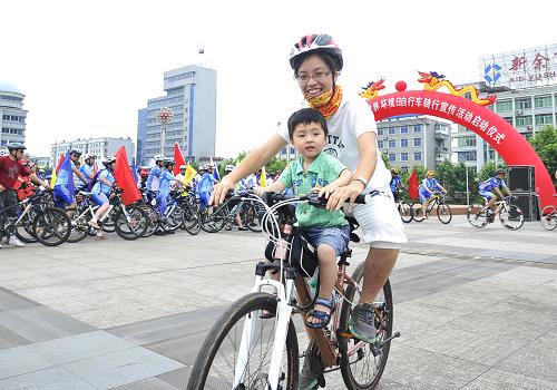6月1日,江西省新余市的一對(duì)母子騎車在街頭進(jìn)行世界環(huán)境日宣傳活動(dòng)。 新華社發(fā)(趙春亮 攝)