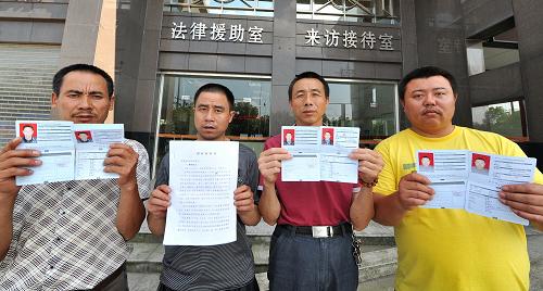 6月19日,被騙至蒙古國采金的湘籍農(nóng)民工代表在常德市總工會(huì)法律援助工作站前展示部分維權(quán)材料。新華社記者 龍弘濤 攝
