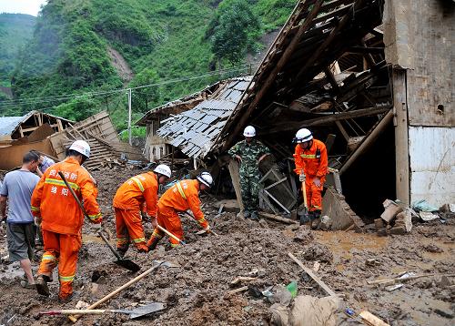 7月12日,救援人員在泥石流現(xiàn)場搜救失蹤人員。