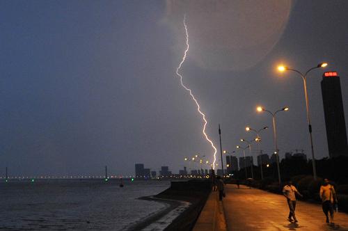 7月30日,幾位行人正冒雨走在錢塘江江堤上,背后一道閃電劃過(guò)。當(dāng)日,浙江省杭州、寧波、紹興、金華、臺(tái)州和湖州六個(gè)地區(qū)實(shí)施人工降雨作業(yè),浙江各地普降雷陣雨,給高溫不退的浙江帶來(lái)了難得的雨水和清涼。7月份以來(lái),浙江各地40攝氏度高溫延續(xù)多天,平均降水量偏少七成。新華社記者 王定昶 攝
