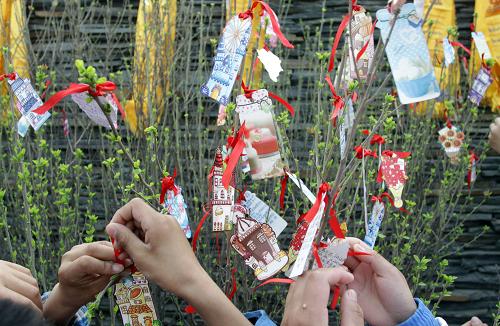 4月14日,在天津耀華濱海學(xué)校,參加悼念活動的玉樹學(xué)生把寫有悼念、祈福字樣的小卡片系在小樹上。當(dāng)日是玉樹地震一周年紀(jì)念日,天津耀華濱海學(xué)校舉行“緬懷同胞、祈福平安、心系玉樹、肩負(fù)責(zé)任”悼念活動,同學(xué)們緬懷逝者,為重建玉樹加油鼓勁。目前,共有500多名來自玉樹災(zāi)區(qū)的學(xué)生在天津耀華濱海學(xué)校就讀。新華社發(fā)(劉東岳 攝)