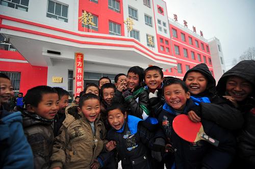 12月6日,甘肅省積石山保安族東鄉(xiāng)族撒拉族自治縣吹麻灘小學(xué)學(xué)生們在教學(xué)樓前玩耍。新華社記者 張錳 攝
