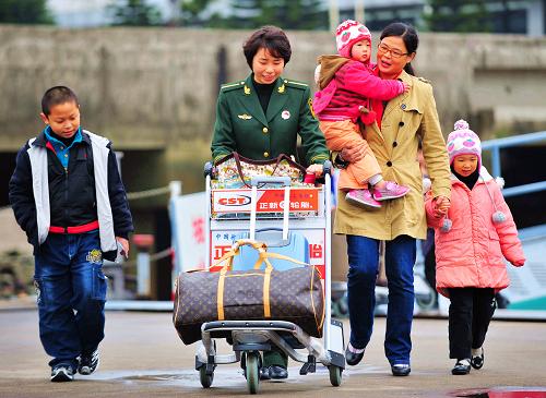 1月29日,福州邊防檢查站民警協(xié)助來自臺(tái)北的旅客張華(右二)搬運(yùn)行李。新華社記者 魏培全 攝