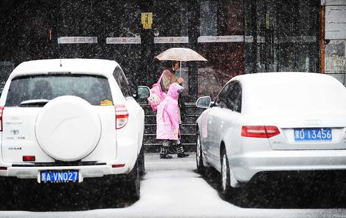 4月12日,市民帶著孩子在雪中行走。新華社記者 王建威 攝
