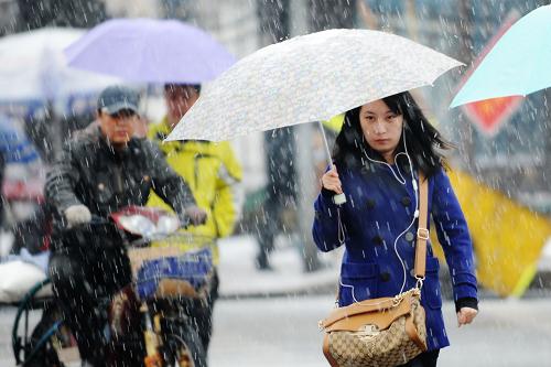 4月12日,市民打傘在雪中行走。新華社記者 王建威 攝