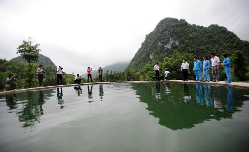 在廣西百色市田陽縣五村鄉(xiāng)雷圩村大卜屯,有關人員和當地群眾在查看水柜蓄水情況(5月9日攝)。新華社記者 陸波岸 攝