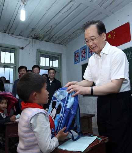 “六一”國際兒童節(jié)前夕,中共中央政治局常委、國務(wù)院總理溫家寶在湖南湘西武陵山區(qū)調(diào)研扶貧開發(fā)工作時,專程到當?shù)剞r(nóng)村小學(xué),看望慰問師生特別是在校的留守兒童,祝他們節(jié)日快樂。 5月25日,在古丈縣默戎鎮(zhèn)毛坪村教學(xué)點——毛坪小學(xué),溫家寶為孩子們帶來了新書包。當工作人員遞上一個粉紅色書包讓總理給8歲的龍英俊時,他不要:“我是男生,不要這個顏色。”這情景把大家都逗樂了。“哦,忘了你是個男子漢!”溫家寶趕緊讓人換了一個藍色書包。這個富有個性的“小男子漢”接在手中,站起來給總理敬了個禮。新華社記者 龐興雷 攝