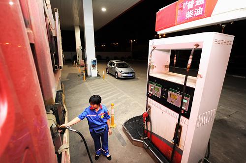 7月11日凌晨,安徽合肥一處加油站的工作人員在為機(jī)動(dòng)車(chē)加油。新華社記者 杜宇 攝