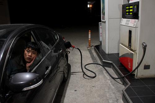 7月11日,一位司機(jī)在安徽合肥一處加油站加油。 新華社發(fā)(張端 攝)