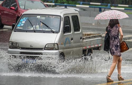 7月12日,重慶市江北區(qū),市民冒雨出行。新華社記者 陳誠(chéng) 攝