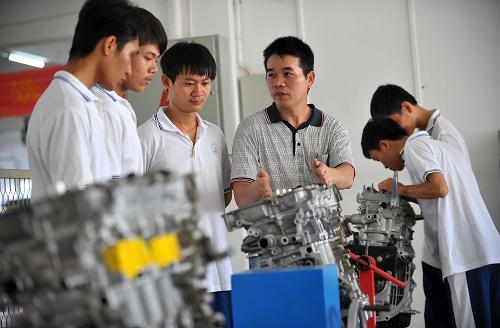海南省機電工程學(xué)校老師郭奇峰(左四)在為汽車專業(yè)的學(xué)生上課(9月12日攝)。新華社記者 郭程 攝