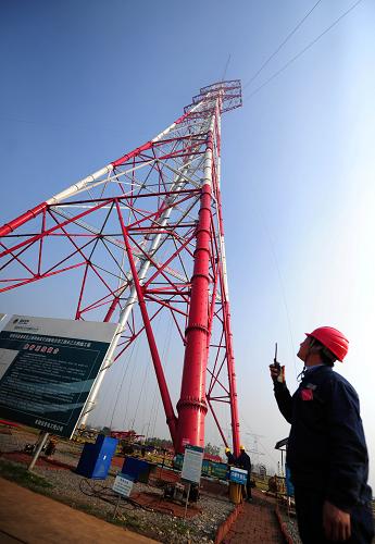 世界最高特高壓輸電跨越塔封頂 10月28日,在安徽省銅陵縣,安徽送變電工程公司的地面指揮人員通過對講機(jī)與高空作業(yè)人員聯(lián)系。 當(dāng)日,由安徽送變電工程公司承建的“皖電東送”淮南至上海特高壓交流輸電示范工程長江南岸跨越鐵塔封頂。 我國首條同塔雙回路特高壓交流輸電工程——“皖電東送”工程西起安徽淮南,經(jīng)皖南、浙北到達(dá)上海,線路全長656公里,共有1421座鐵塔,整個工程計劃2013年底建成投運(yùn)。工程建成后,每年將能輸送超過500億度電,相當(dāng)于為上海新建了6座百萬千瓦級的火電站。 目前,該工程已進(jìn)入最為關(guān)鍵的跨越長江階段,為此建設(shè)的跨越鐵塔高達(dá)277.5米。該工程跨越長江長度約3公里,通過立于長江南北岸的兩座輸電塔直接放線跨越。由于采用的是兩條回路都通過同一座輸電塔進(jìn)行跨越,線路自重超過一般線路兩倍以上,對跨越鐵塔的塔基牢固性、塔身穩(wěn)定性的要求超過以往,屬于世界同類塔中高度最高、施工難度最大的一項工程。 新華社發(fā)(鄭賢列 攝)