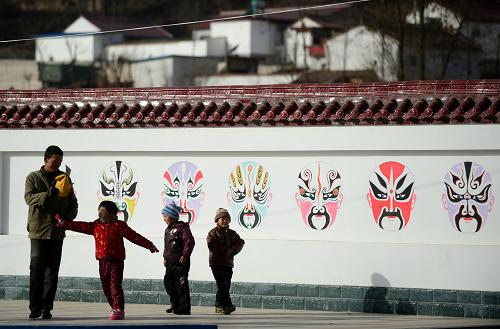 隴東煤都打造人居新環(huán)境 11月28日,在甘肅省華亭縣東華鎮(zhèn)月元村村民文化小廣場,人們從文化墻旁走過。 素有“隴東煤都”之稱的甘肅省華亭縣因煤而興的同時,也因采煤帶來了發(fā)展中的諸多難題,曾經(jīng)一些產煤區(qū)生態(tài)環(huán)境遭受破壞,地面沉降、裂縫、滑塌隨處可見。為此,該縣堅持“生態(tài)文化山城,綠色能源之都”的發(fā)展理念,投入巨資對采礦滑坡、塌陷地塊進行治理。從昔日晴天一身灰、雨天兩腿泥的煤城小縣到宜商宜居宜游區(qū)域中心小城市,從過去又黑又臟的“煤黑子”到如今人人羨慕的現(xiàn)代化礦工。如今,華亭縣已建成全國文明縣城、國家園林縣城,打造成為文明靚麗新煤都。 新華社記者 張錳 攝