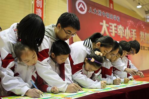 新學(xué)期 新氣象 2月25日,在北京市人大附中朝陽學(xué)校的新學(xué)期開學(xué)典禮上,小學(xué)生和高中生一同簽署象征互相幫助的承諾卡。 當天,北京市中小學(xué)學(xué)生迎來寒假后正式開學(xué)的第一天。在人大附中朝陽學(xué)校的開學(xué)典禮上,校方表示要將小學(xué)與高中學(xué)生的“聯(lián)誼”融入到未來的教學(xué)當中。 新華社記者鄭煥松攝
