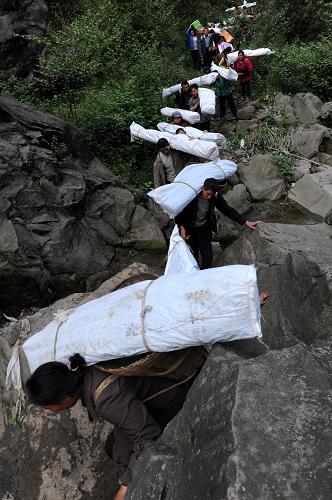 “螞蟻搬家”救災物資進孤島 4月22日,石鳳村村民在搬運救災援助物資。 地震發(fā)生以來,蘆山縣雙石鎮(zhèn)石鳳村唯一的進村道路因巨石墜落、路基塌方造成完全阻斷。這里與外界隔絕,嚴重缺少帳篷和各種食物。由于進村道路狹窄,大型工程車輛無法進入作業(yè),道路搶通救援隊多次突破都未能打通。 全村及附近村組2000多名村民藥品、食品告急。村民不等不靠,上至65歲的老人,下至7歲的孩子,迅速組織起了一支300多人的搬運隊伍,專門擔負各種救災物資的人力輸送。 據(jù)村民張彬芳介紹,出發(fā)前村民們約法三章,搬運的物資除必須留出分留給前來支援救災的解放軍和武警戰(zhàn)士外,剩下的統(tǒng)一運送、統(tǒng)一分發(fā)、照顧老弱病殘和傷員。 從道路斷口到村口5公里的路程,有很大部分是在密林山地中新開辟的道路,300多村民用“螞蟻搬家”的方式,完全靠人力將40多噸救災物資運進孤島,讓全村渡過了物資匱乏的難關(guān),且未出現(xiàn)強占為私和無序哄搶的情況。 新華社記者 李紫恒 攝